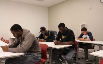 Saddleback College students engaging with their phones rather than with each other.