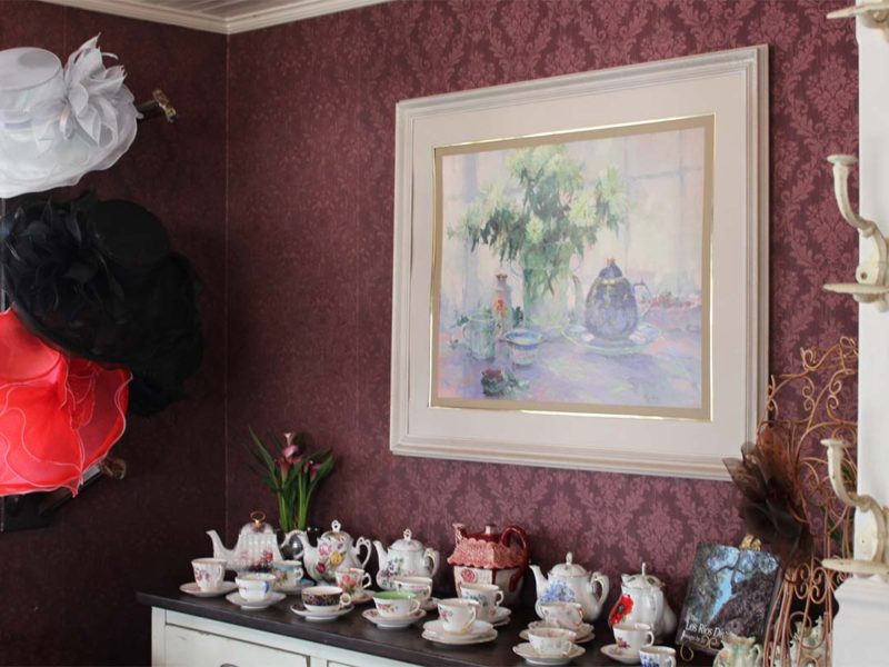 Multiple tea hats and porcelain tea sets arranged in the dining room. (Celeste Espinoza)